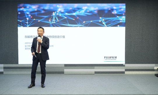 A person in a suit standing on a stage

Des<i></i>cription automatically generated